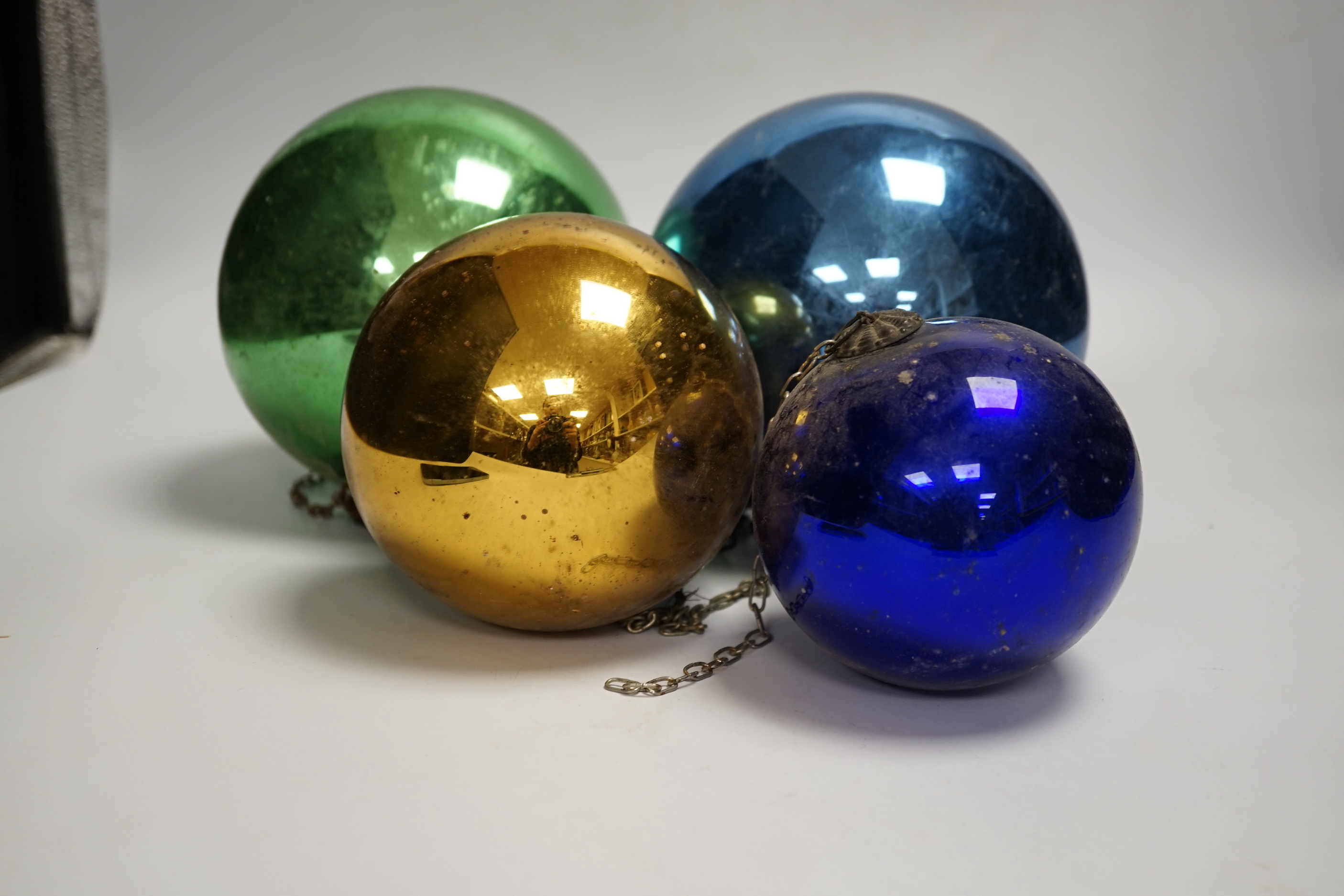 Four various metallic coloured witch’s balls, (dark blue, green, gold and light blue)